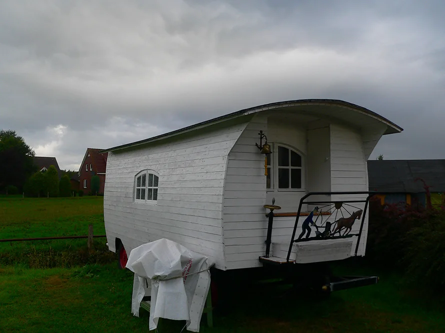 Weißer Bauwagen auf einem Feld