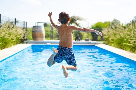 Kind springt in einen Pool