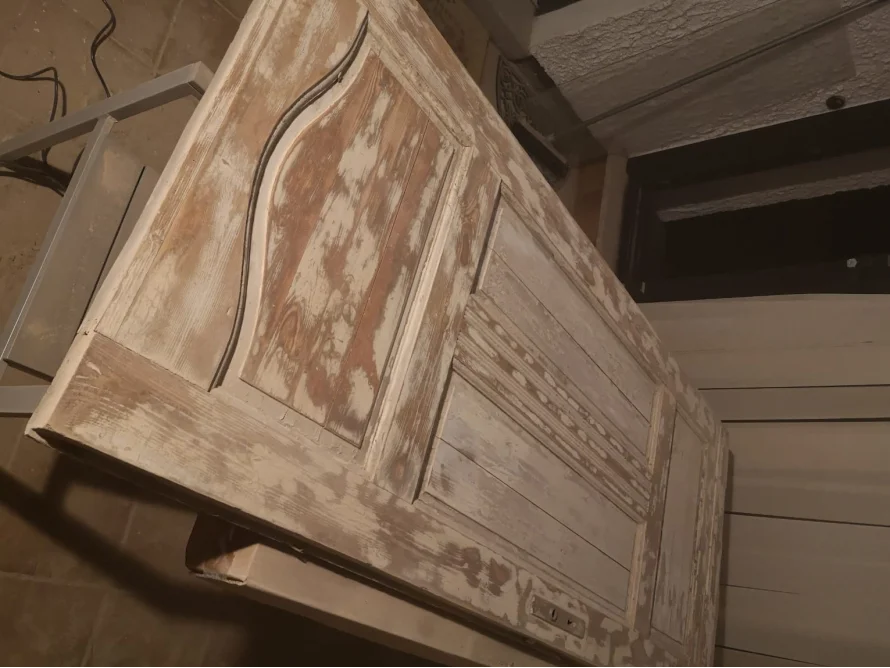 Abgenutzte Holztür mit weißen Farbresten