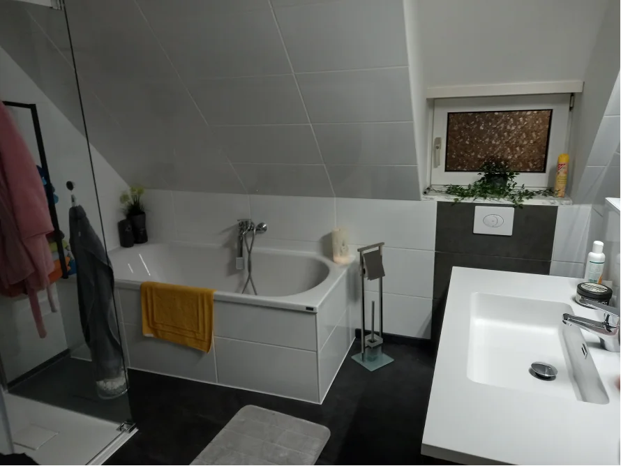 Modernes Badezimmer mit Badewanne und Dusche.