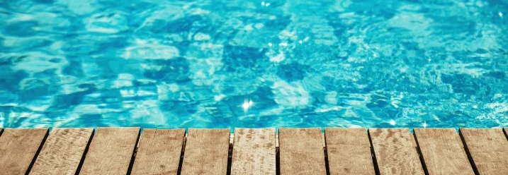 Holzsteg an einem blauen Pool
