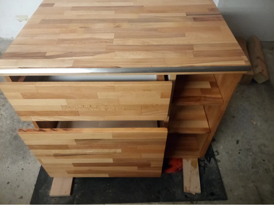 Küchenregal aus hellem Holz mit offenen Fächern und Schubladen