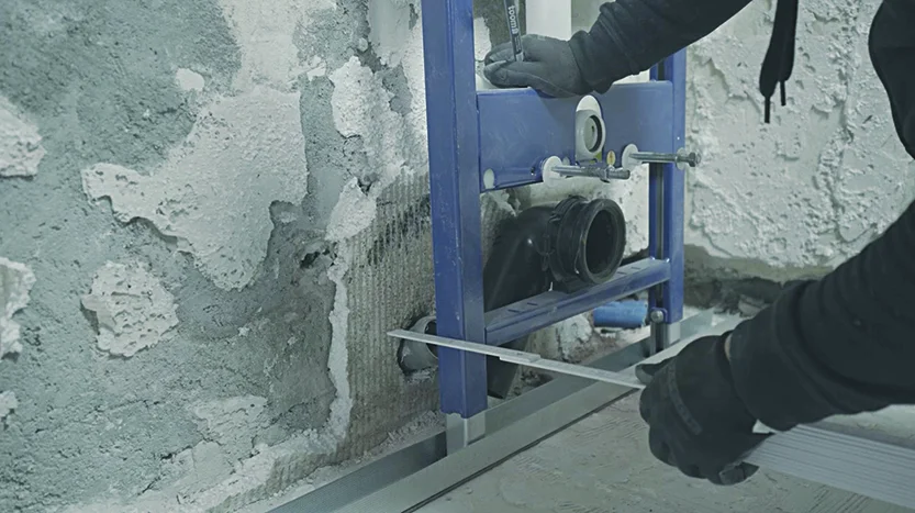 Person richtet Metallschiene mit Wasserwaage aus