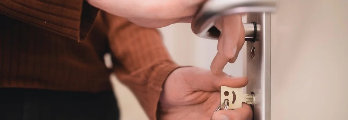Person schließt Tür mit Schlüssel auf