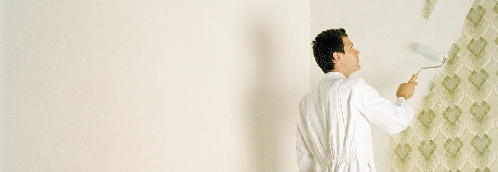 Person streicht Tapete mit Muster
