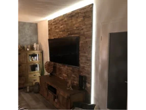 Wohnzimmer mit Holzwand und Fernseher