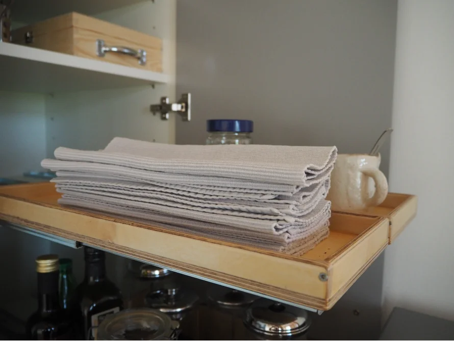 Gestapelte Geschirrtücher auf einem Ausziehregal