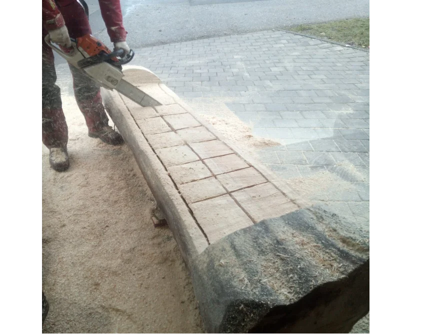 Person schneidet mit Kettensäge Holzbalken