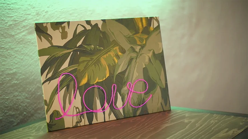 Bild mit Blättern und pinker Lichtschrift 