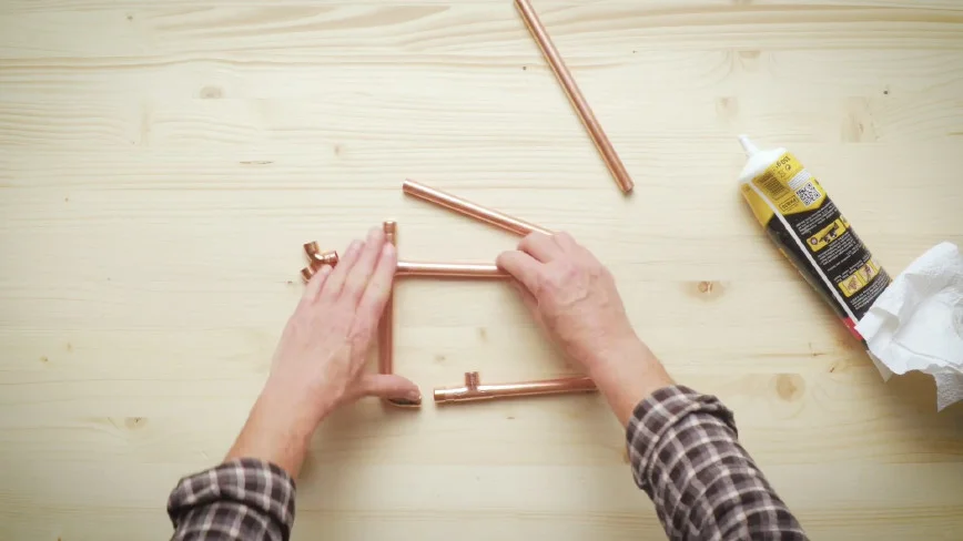 Hände bauen Kupferrohrgestell