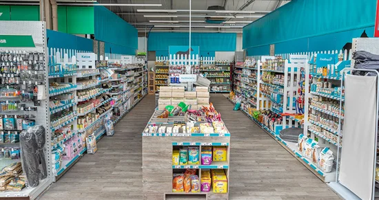 Gang in einer Tierbedarf-Abteilung mit vielen gut gefüllten Regalen.