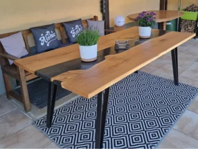 Ein Esstisch aus hellem Holz mit einer schwarzen Einlage