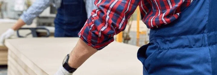 Zwei Personen tragen eine Holzplatte