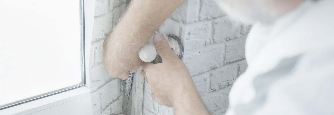 Person bringt Tapete an Fenster an