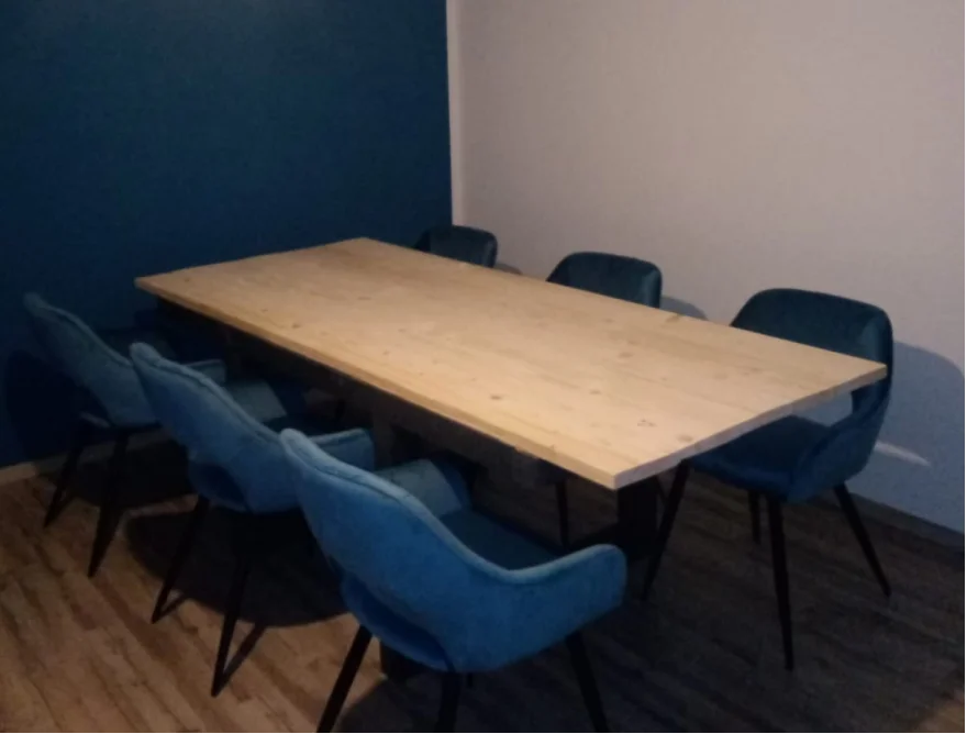 Heller Holztisch mit blauen Stühlen