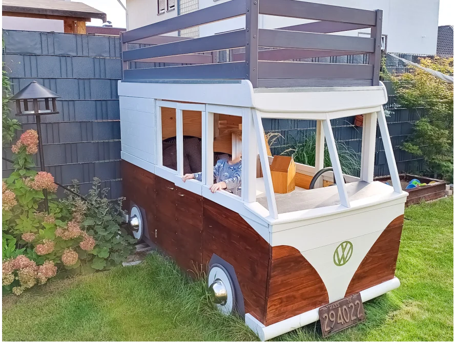 Kind in einem Spielhaus in Form eines Bullis