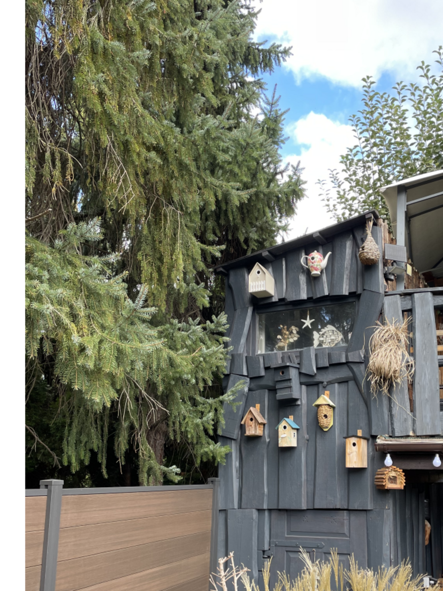 Graues Baumhaus aus Holz im Garten