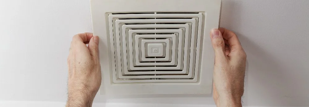 Hände befestigen Abdeckung eines Badlüfters.