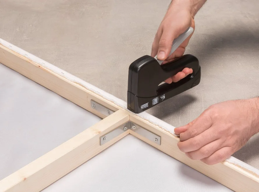 Person benutzt einen Tacker.