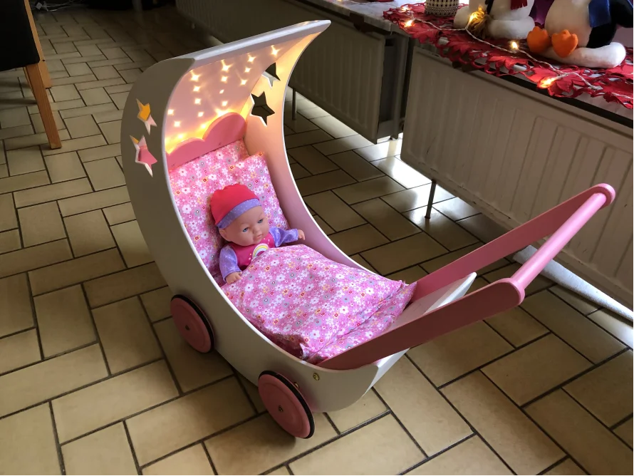 Puppenwagen in Form eines Halbmondes mit Puppe