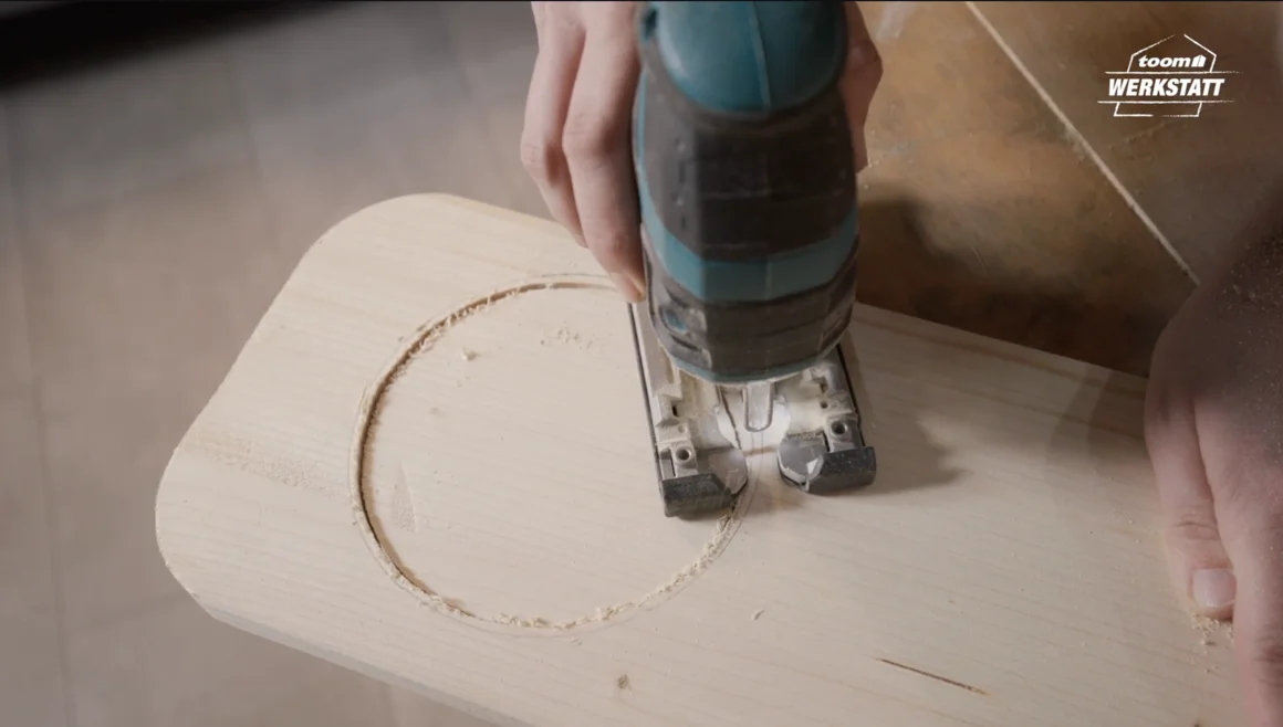 Person sägt Kreis in Holzbrett