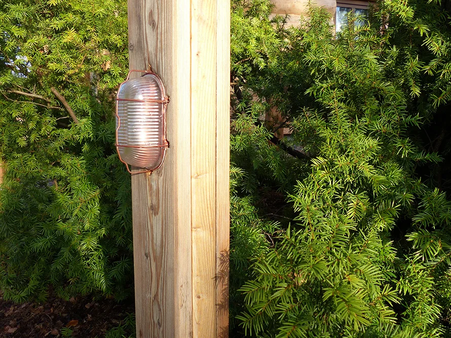 Außenlampe an einem Holzpfahl