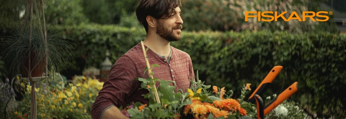 Person hält Pflanzen und Gartenschere