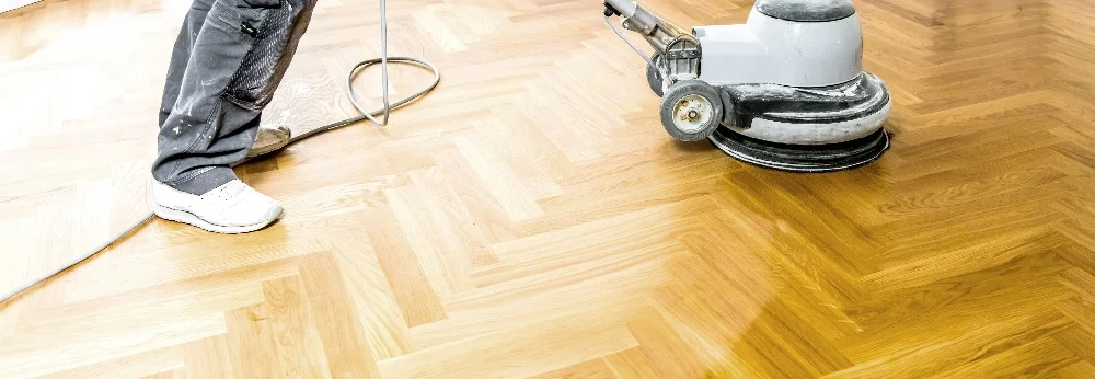 Person schleift Parkettboden