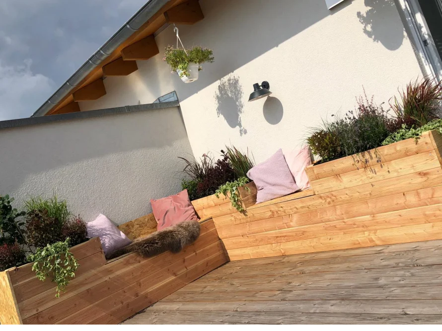 Holzterrasse mit Hochbeet und Sitzgelegenheit