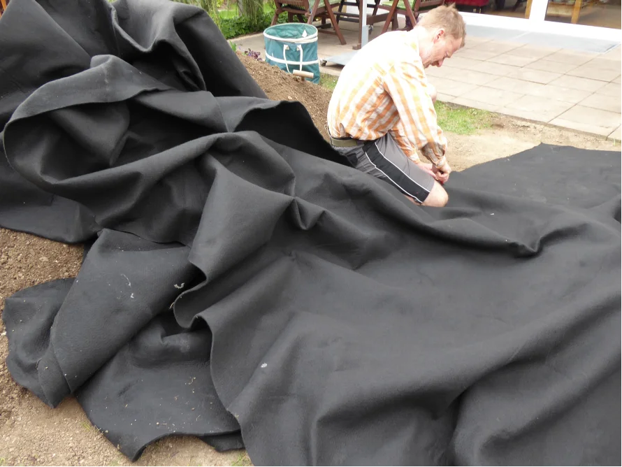 Person verlegt Gartenvlies