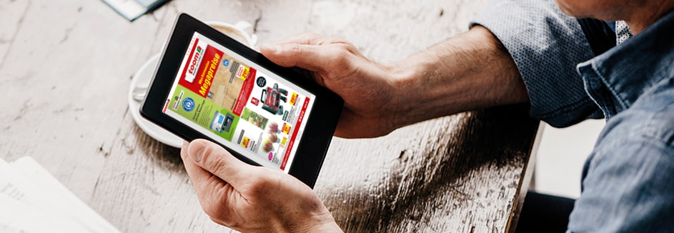 Person blättert in einem digitalen Prospekt auf einem Tablet.