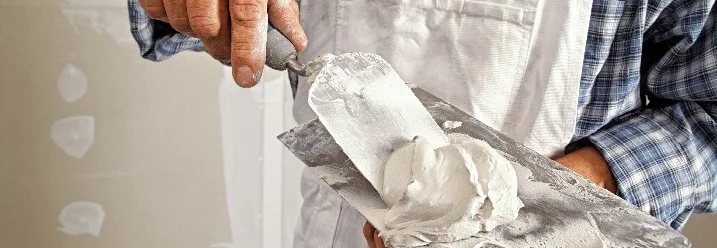 Person hält Spachtel mit Gips
