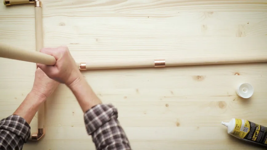 Person baut Holzrahmen zusammen