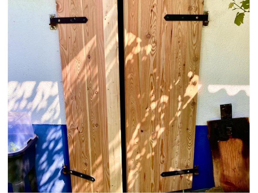 Zwei Holztüren mit schwarzen Scharnieren