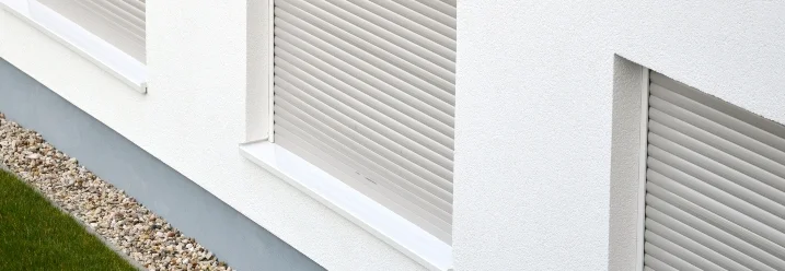 Drei heruntergelassene Rollläden an Hauswand