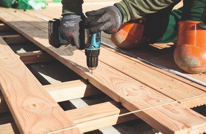 Holzterrasse verlegen Holzdielen werden auf die Unterkonstruktion geschraubt.