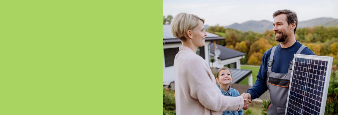 Frau schüttelt Arbeiter mit Solarpanel die Hand