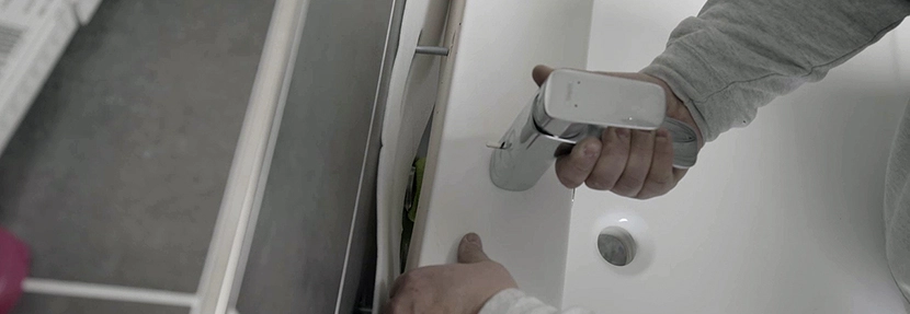 Person montiert einen Wasserhahn.