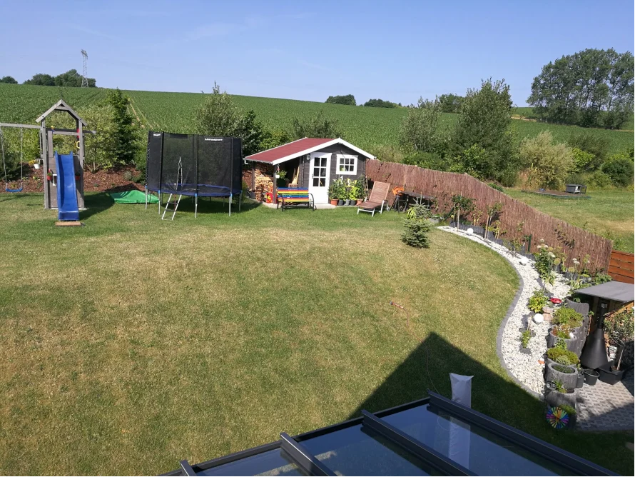 Garten mit Spielgeräten und Gartenhaus