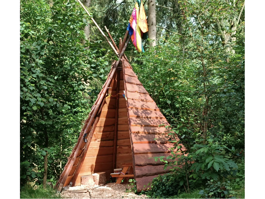 Hölzernes Tipi im Wald