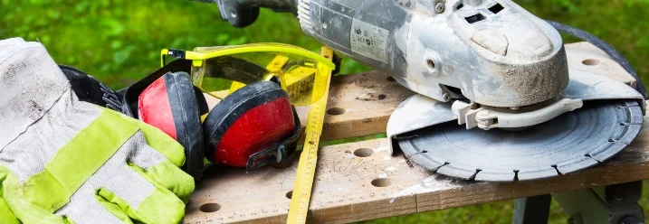 Handkreissäge neben Schutzbrille und Handschuhen