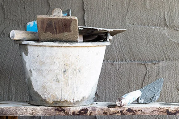 Eimer mit Maurerkelle und Werkzeug