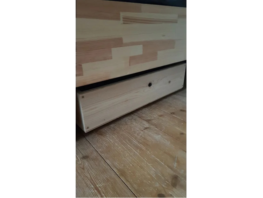 Offene Holzschublade unter Bett