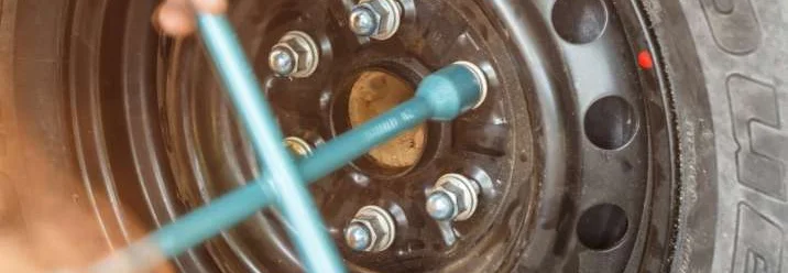 Person verwendet Drehmomentschlüssel an Autoreifen