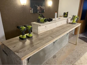 Unfertige Holztheke mit Akkuschraubern und Stichsäge