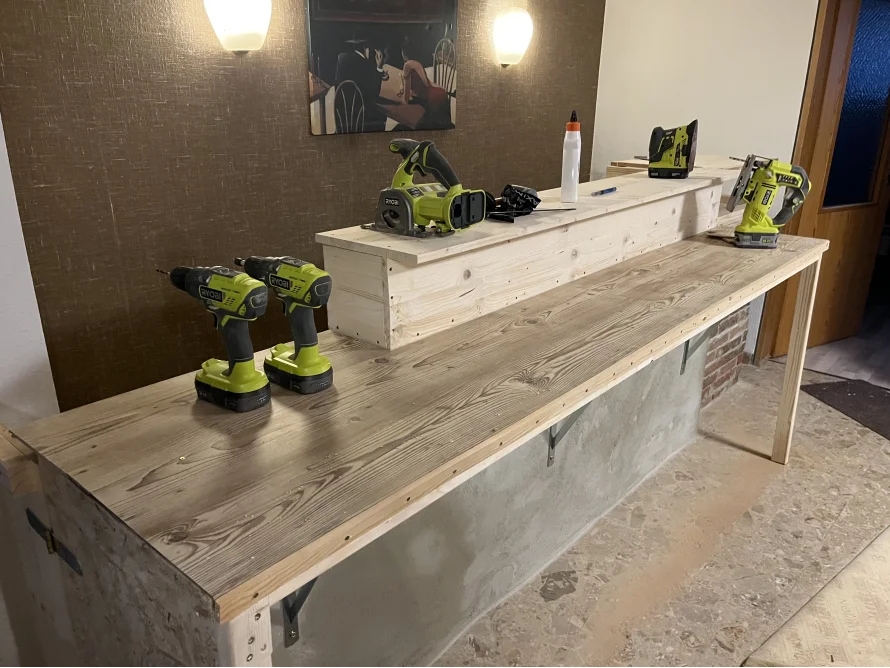 Unfertige Holztheke mit Akkuschraubern und Stichsäge