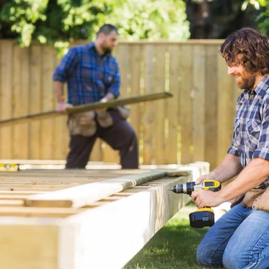 Zwei Personen bauen eine Holzterrasse