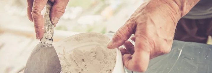Person trägt Spachtelmasse auf