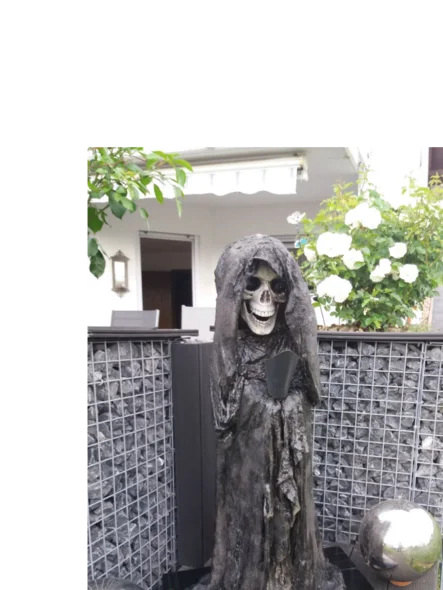 Skelettfigur mit Sense in einem Garten