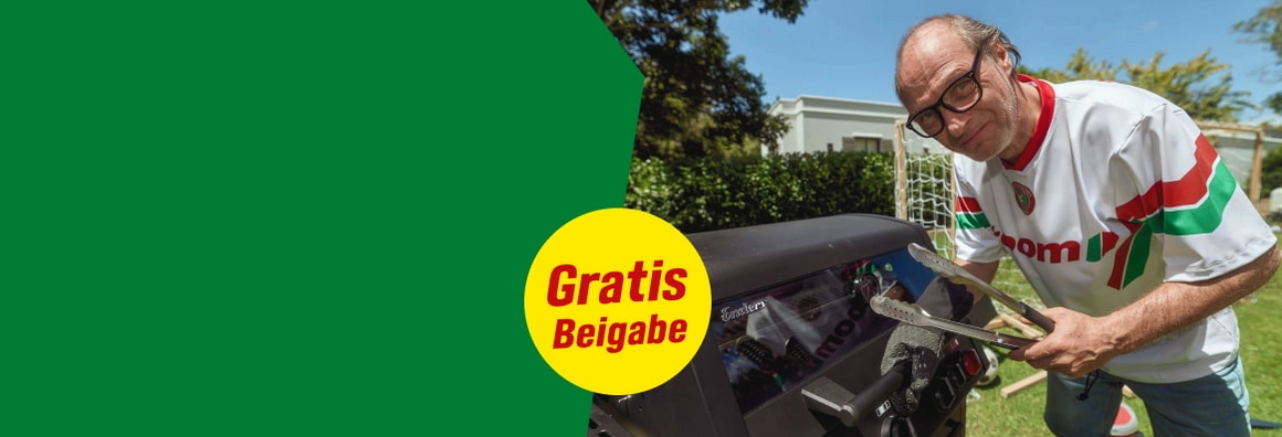 Gratis Beigabe. Person mit Grillzange steht an einem Grill im Garten.